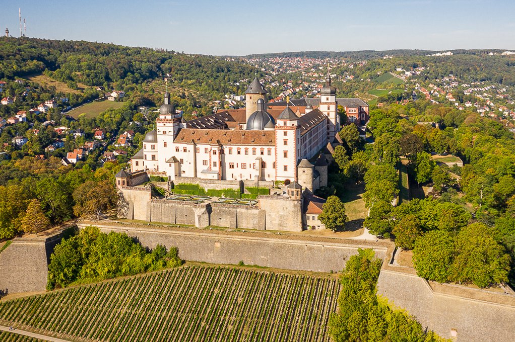 Die Festung Marienberg aus der Vogelperspektive im Sonnenschein mit den grünen Hügeln und Weinbergen im Herzen von Würzburg.. Foto: © CTW Dietmar Denger Die Festung Marienberg aus der Vogelperspektive im Sonnenschein mit den grünen Hügeln und Weinbergen im Herzen von Würzburg.. Foto: © CTW Dietmar Denger